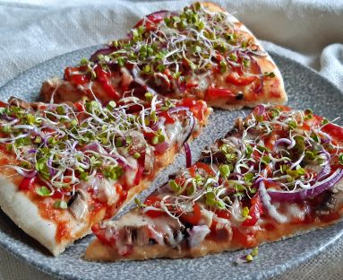 Wiosenna pizza na cienkim cieście z kiełkami rzodkiewki, serem, czerwoną cebulką i pieczarkami