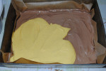 wykładanie masy serowej na pierwszą warstwę ciasta czekoladowego