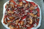 pizza z kurczakiem i pieczarkami przed pieczeniem