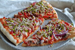 Wiosenna pizza na cienkim cieście z kiełkami rzodkiewki, serem, czerwoną cebulką i pieczarkami