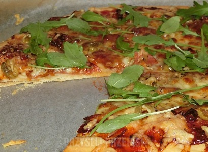 Pizza z mozzarellą, suszonymi pomidorami i rukolą