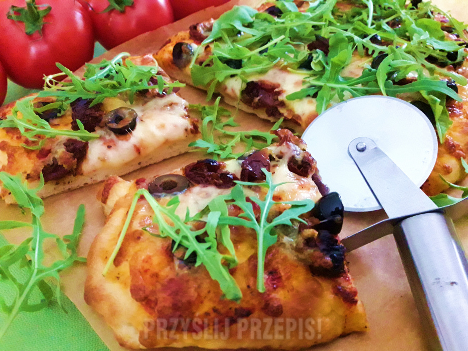 Pizza z suszonymi pomidorami, oliwkami, mozzarellą i rukolą