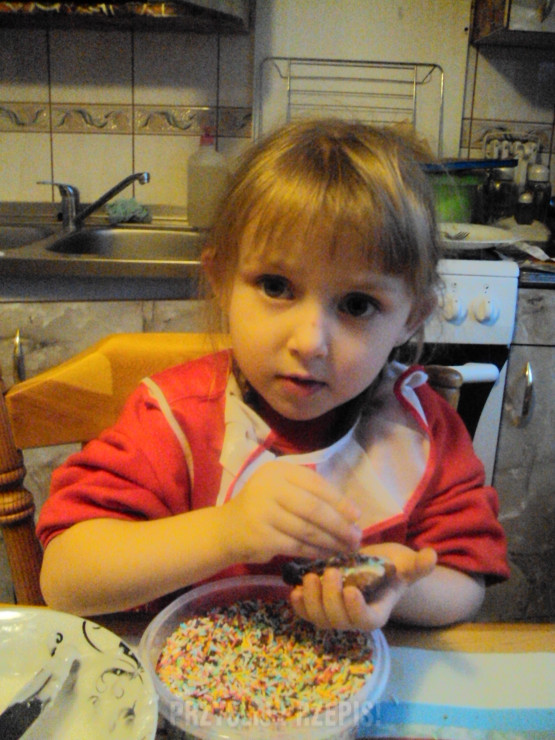 Emilka pomaga dekorować pierniki.