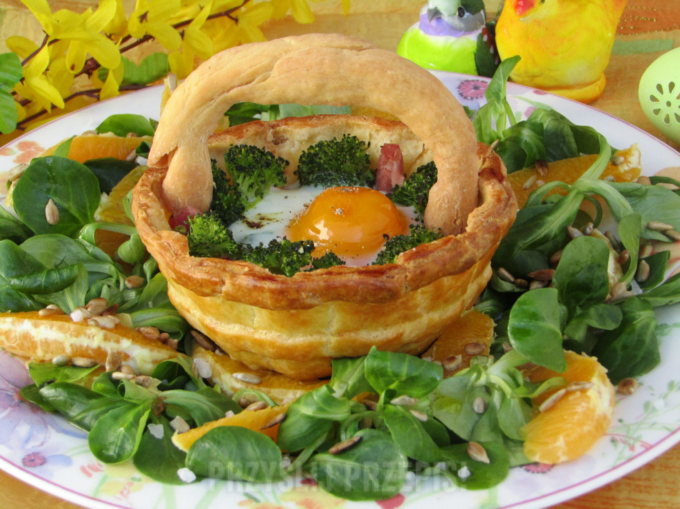 Jajko zapiekane na brokule i szynce w kruchym koszyczku, podane na lekkiej sałatce z roszponki, pomarańczy i słonecznika.