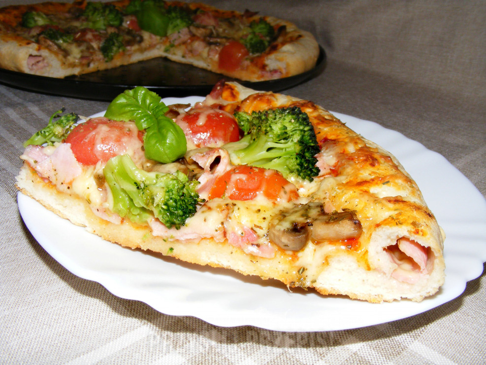 Pizza na puszystym spodzie i faszerowanymi brzegami z szynka, boczkiem, pieczarkami,  brokułem i pomidorkami