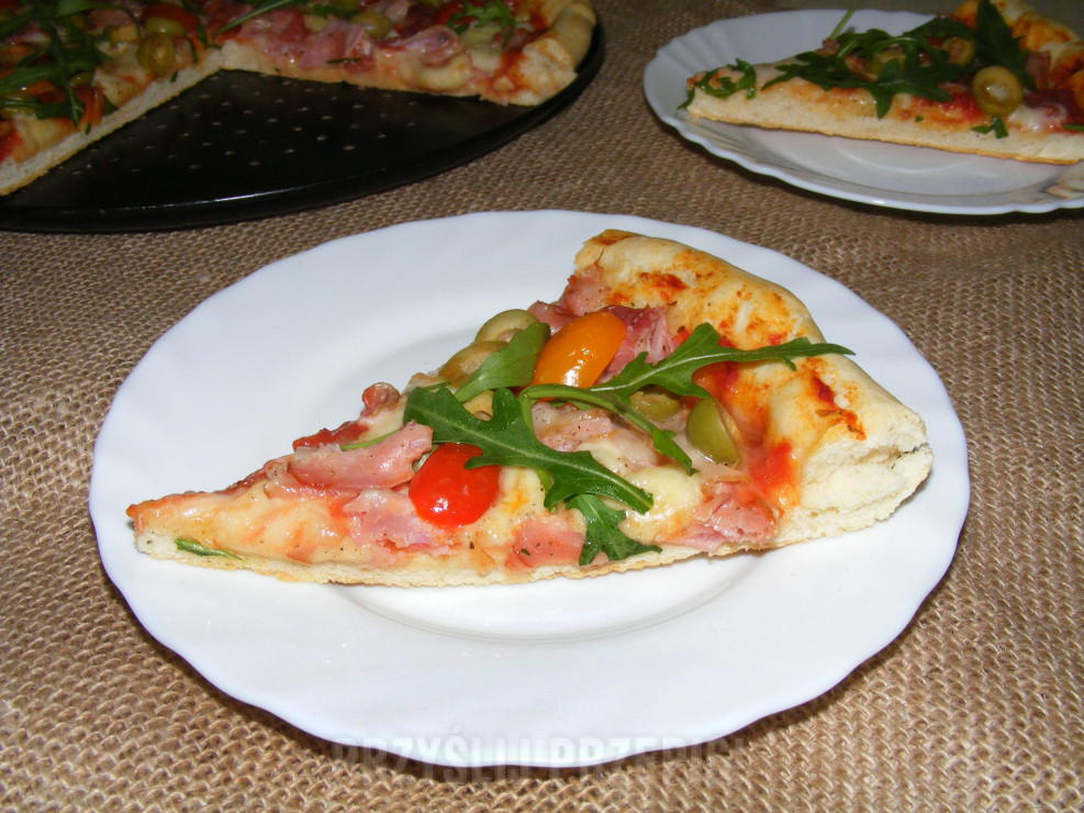 Pizza z mozzarellą, pomidorkami, szynką parmeńską i rukolą