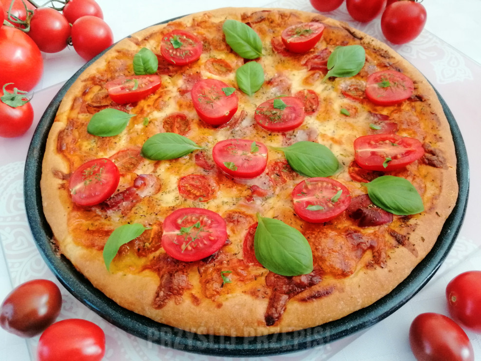 Pizza z szynką parmeńską , pomidorkami cherry , mozzarella i serem gouda