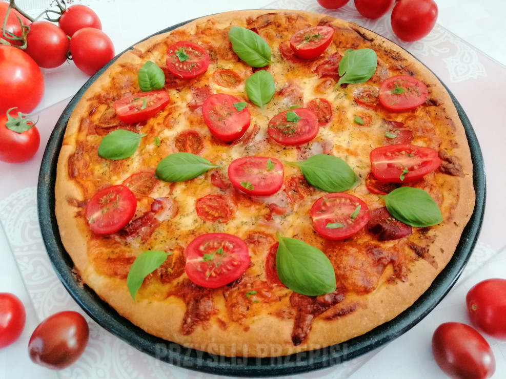 Pizza z szynką parmeńską , pomidorkami cherry , mozzarellą i serem gouda