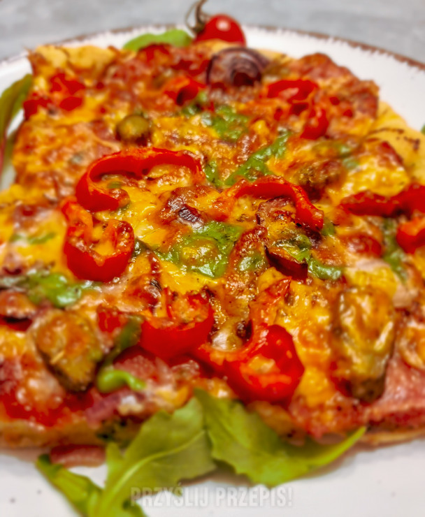 Pizza na grubym cieście, z salami, czerwoną cebulą, papryką i ogórkiem konserwowym
