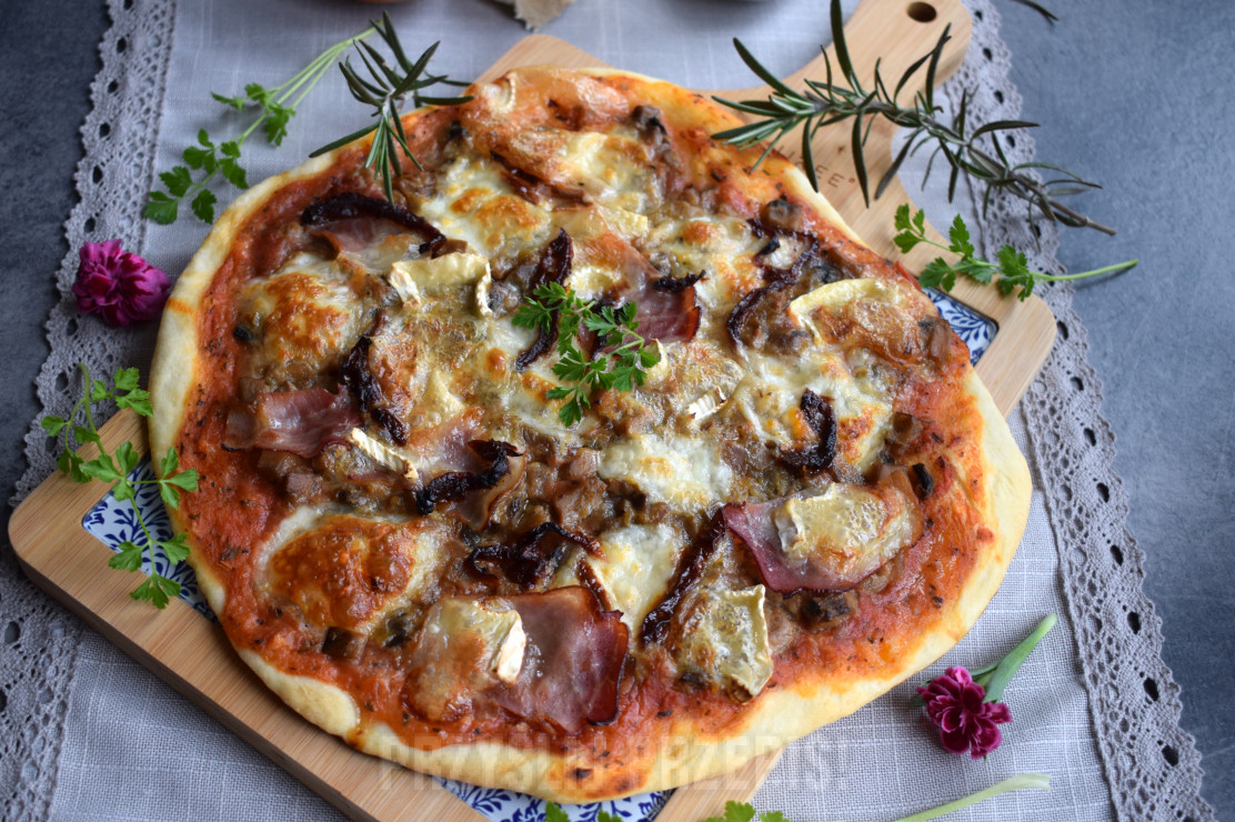 Pizza z szynką parmeńską, serem camembert, suszonymi pomidorami i anchois
