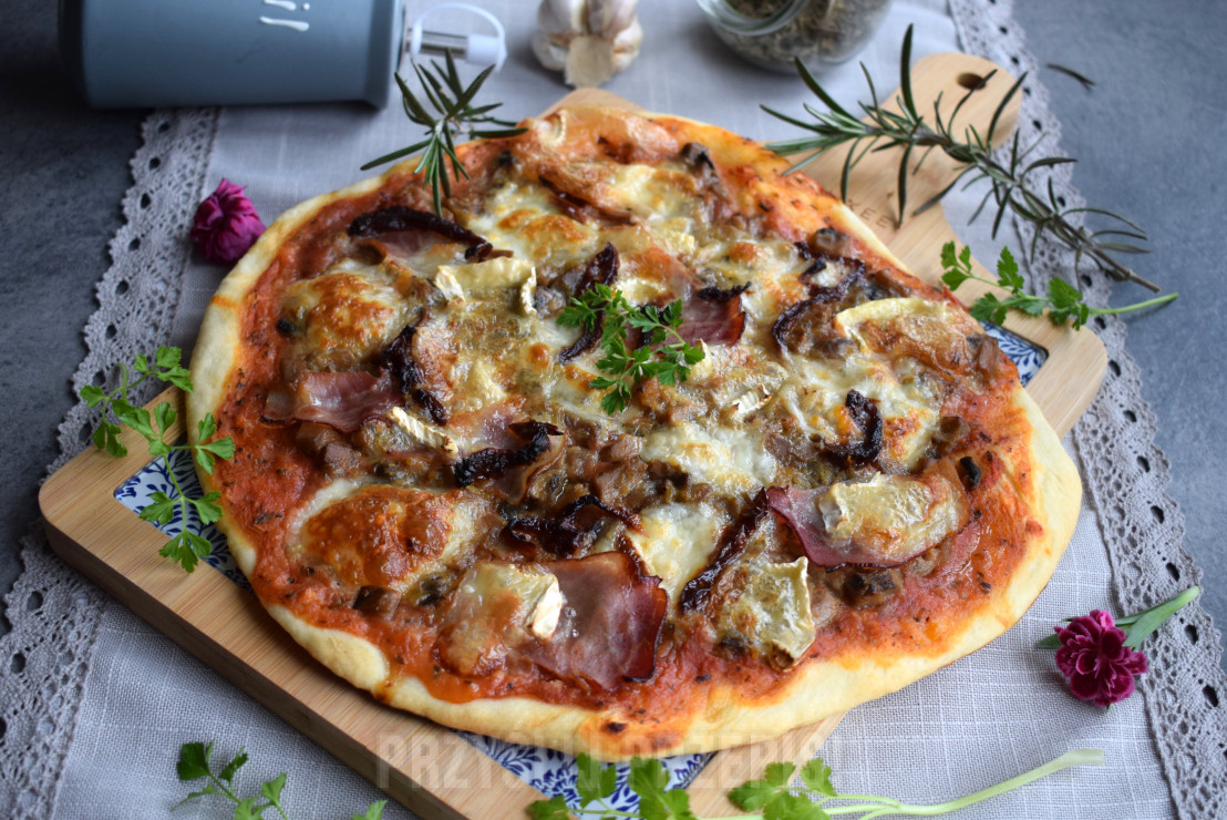 Pizza z szynką parmeńską, serem camembert, suszonymi pomidorami i anchois